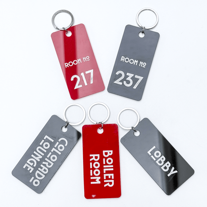 Five laser-cut wooden keychains feature room numbers and location names from The Shining's Overlook Hotel, including Room 217 and the Boiler Room.