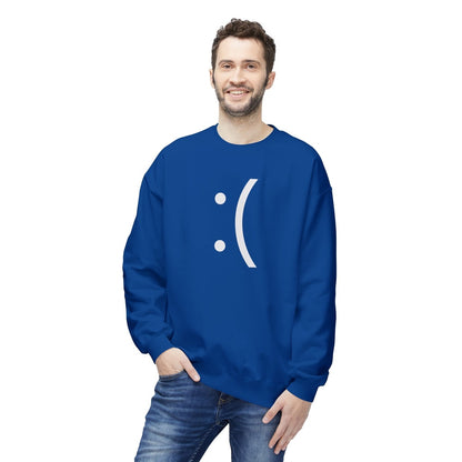 A man wearing a blue sweatshirt displays a white graphic of a sad face emoticon referencing the classic Windows Blue Screen of Death error.