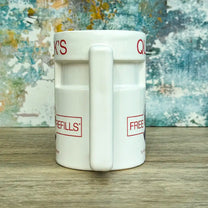 Quarks Bar Mug replica from Star Trek Deep Space Nine labelled "Quark's" with a portrait of Quark and text promoting free refills, against a colourful background