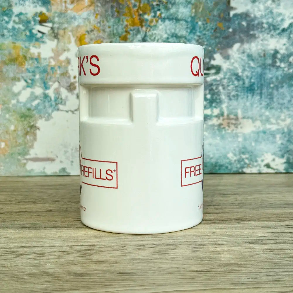 Quarks Bar Mug replica from Star Trek Deep Space Nine labelled "Quark's" with a portrait of Quark and text promoting free refills, against a colourful background
