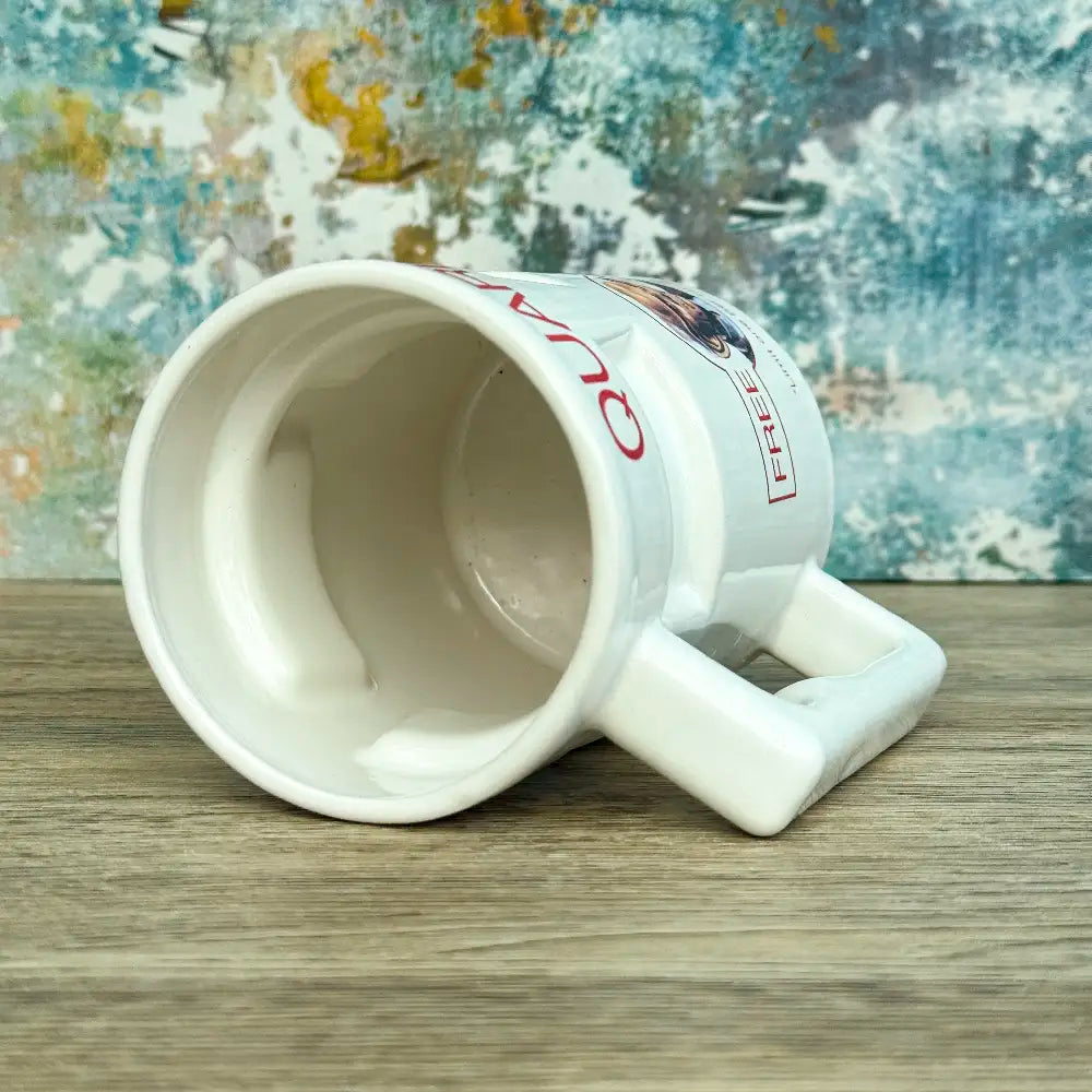 Quarks Bar Mug replica from Star Trek Deep Space Nine labelled "Quark's" with a portrait of Quark and text promoting free refills, against a colourful background