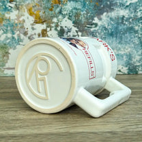 Quarks Bar Mug replica from Star Trek Deep Space Nine labelled "Quark's" with a portrait of Quark and text promoting free refills, against a colourful background
