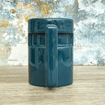 A teal Ops Raktajino mug from DS9 features a rectangular design and prominent handle.
