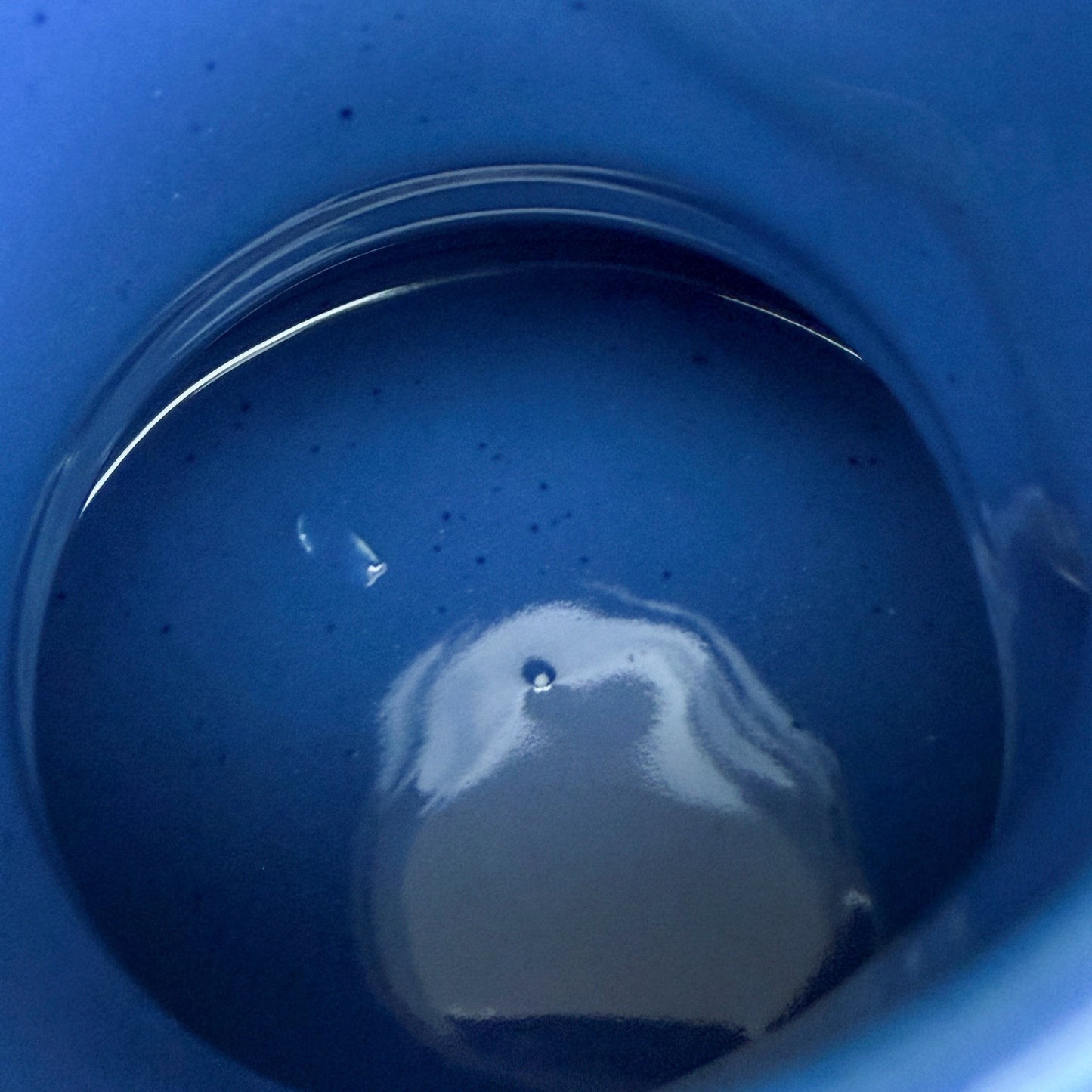 A blue handmade "Rejected Raktajino Mug" by Quirkify, featuring a wide flared base and handle, sits on a wooden surface. A white paper labeled "1" is in front, with a light blue background. Give one a good home today!.