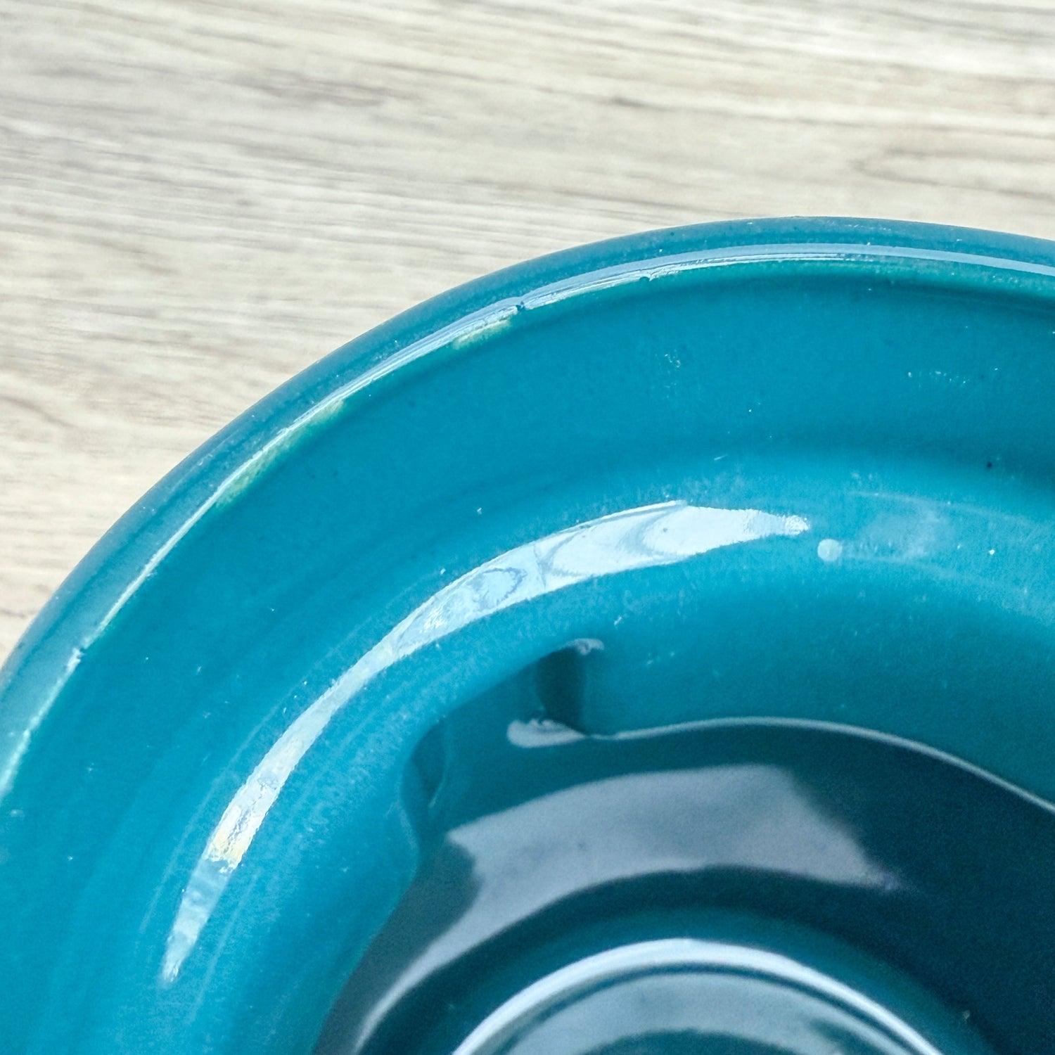 A handmade "Rejected Raktajino Mug" by Quirkify, sitting on a wooden surface. Give one a good home today!.