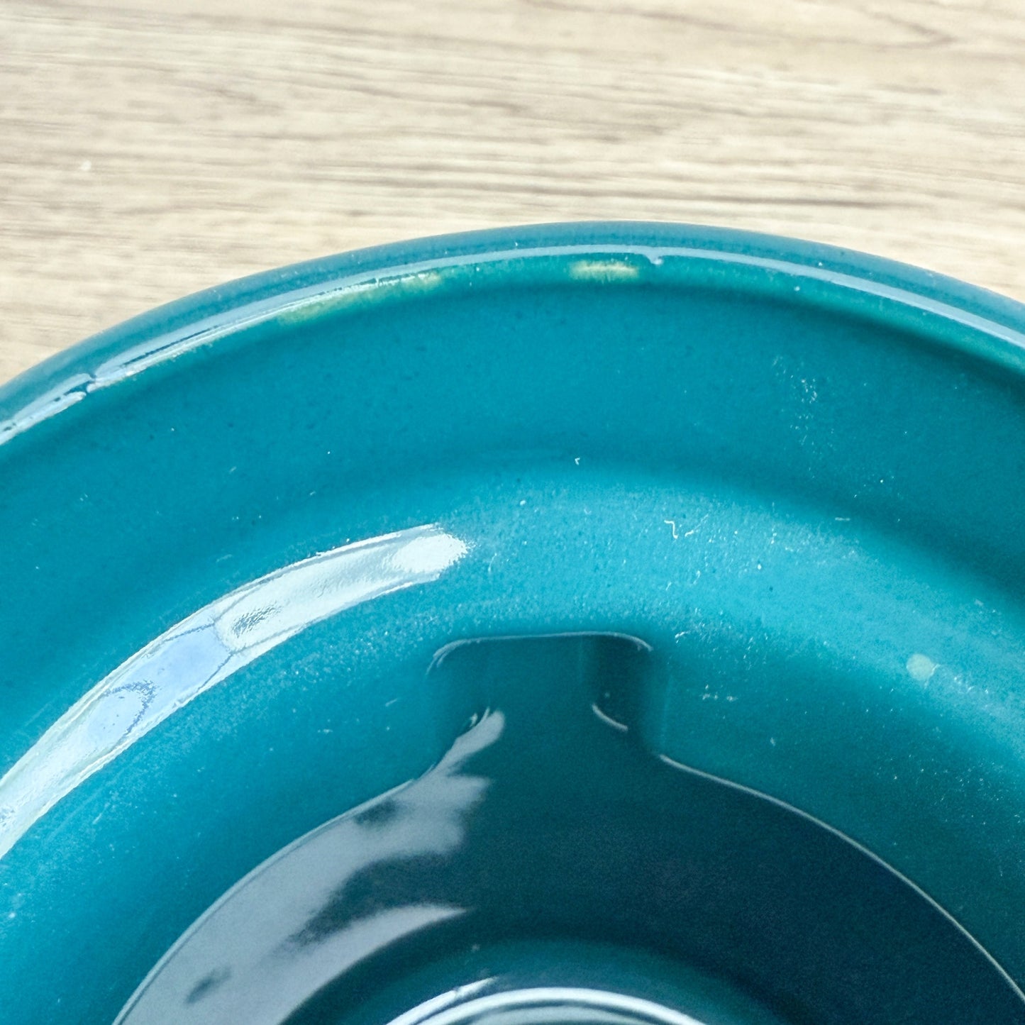 A handmade "Rejected Raktajino Mug" by Quirkify, sitting on a wooden surface. Give one a good home today!.