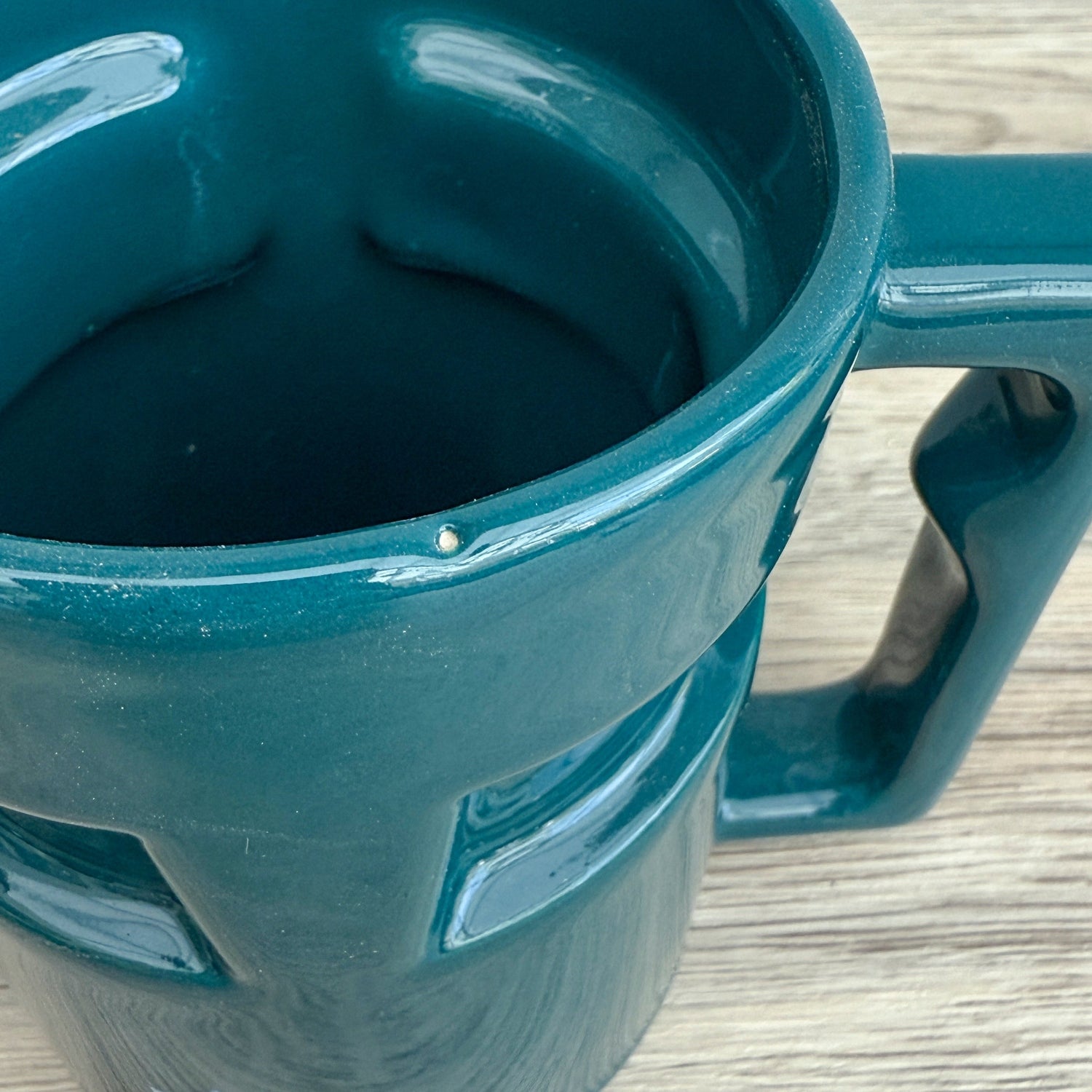 A handmade "Rejected Raktajino Mug" by Quirkify, sitting on a wooden surface. Give one a good home today!.