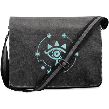 A black Zelda Sheikah Messenger Bag features glow-in-the-dark embroidery of a stylized eye symbol on the front flap.