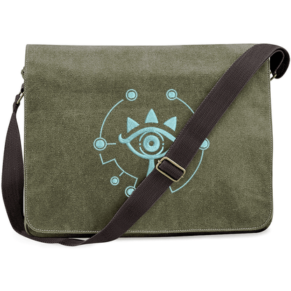 This Zelda Sheikah Messenger Bag features a light blue embroidered design of the Sheikah eye symbol on an olive green background.