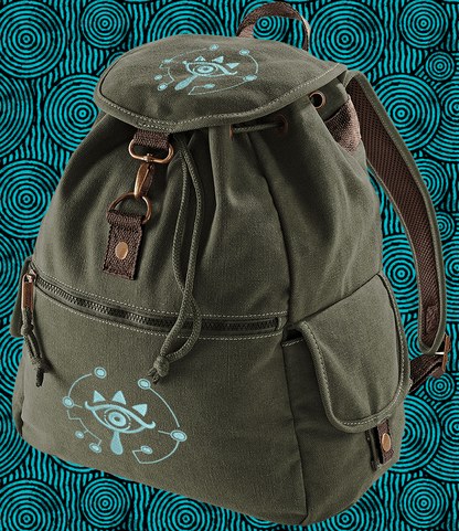 This olive green Zelda Sheikah backpack features glow-in-the-dark embroidery of a stylized eye symbol on the front and top flap.