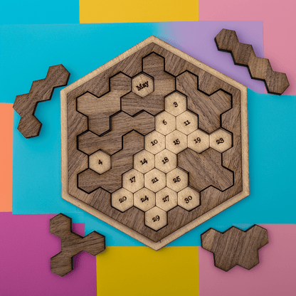 A wooden hexomino date puzzle inspired by Star Trek, featuring numbered segments arranged within a hexagonal frame and several wooden pieces scattered around it.