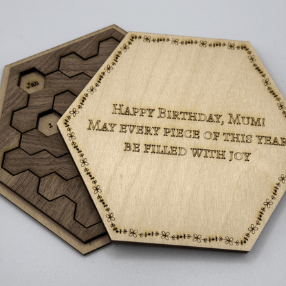 The image shows a Hexagon Calendar Puzzle Gift Edition featuring wooden tiles arranged in a hexagonal shape and inscribed with "Happy Birthday, Mum!