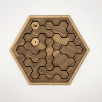 A wooden hexomino puzzle, inspired by Star Trek, features interlocking pieces and labels "Jan" and "I" on two of them.