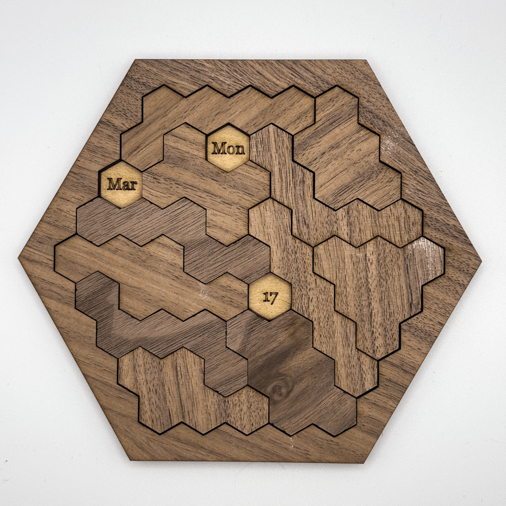 This wooden hexomino puzzle, inspired by Star Trek, displays the dates "Mar," "Mon," and "17" on rotating sections.