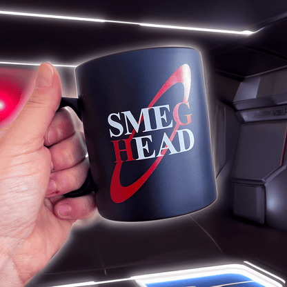 A hand holds a red Smeg Head mug referencing the British sci-fi comedy Red Dwarf.