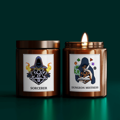 Two DnD scented candles are displayed side-by-side, one labeled "Sorcerer" and the other "Dungeon Mistress," each featuring a D20 dice design with fantasy character illustrations on their labels.