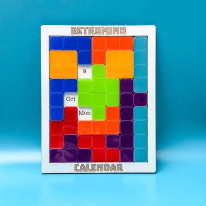 A colorful KronoBlox puzzle calendar displays the date as October 9th, Monday, featuring a Tetromino arrangement and the brand name Retromind.