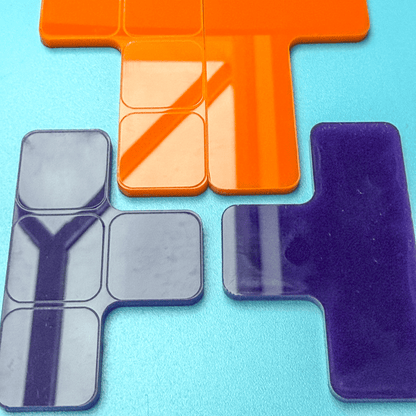 Colorful KronoBlox puzzle pieces are arranged on a blue surface, resembling Tetromino shapes for a perpetual calendar and brain teaser.