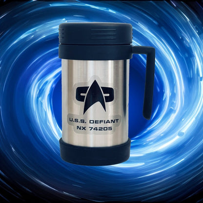 A silver Star Trek inspired travel mug labeled "U.S.S. Defiant NX 74205" sits against a swirling blue background.
