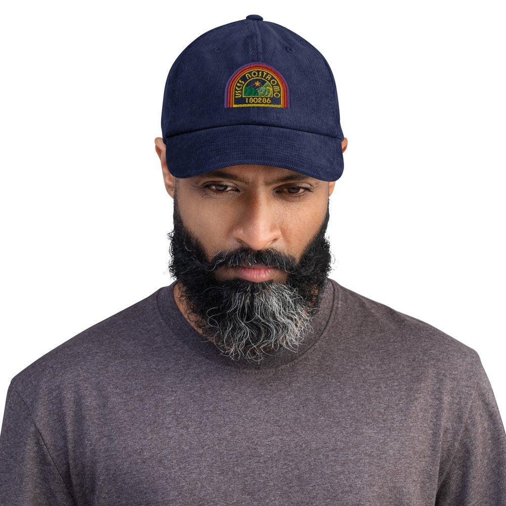 A man wearing a blue Alien USCSS Nostromo embroidered dad hat with a rainbow-style logo on the front.