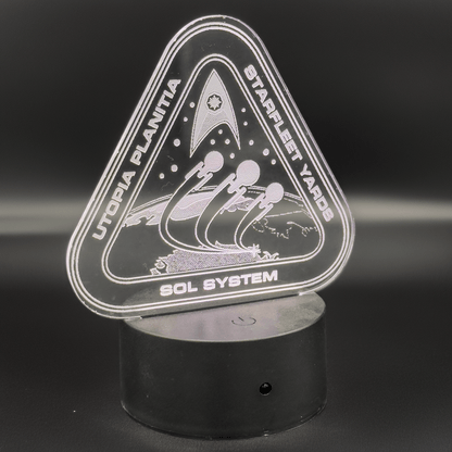 The illuminated acrylic lamp depicts a Starfleet shipyard on Utopia Planitia, featuring spaceships and the Sol System label in an engraved design.