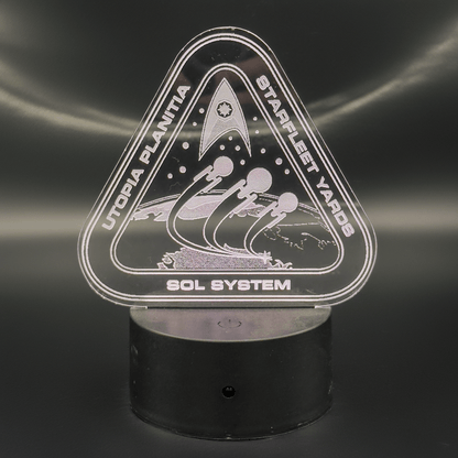 An LED engraved acrylic lamp depicts a Starfleet Yards logo for Utopia Planitia and the Sol System, featuring spacecraft silhouettes.