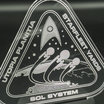 The engraved acrylic lamp depicts a Starfleet Yards insignia featuring stylized spacecraft orbiting Utopia Planitia, along with the words "Starfleet Yards" and "Sol System.