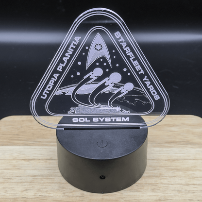 The LED engraved acrylic lamp depicts a Starfleet shipyard scene on Utopia Planitia, labeled "Starfleet Yards" and "Sol System," within a triangular frame.