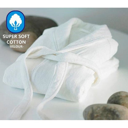 A white cotton velour bathrobe is draped over a surface next to smooth stones, displaying a logo indicating super soft cotton.