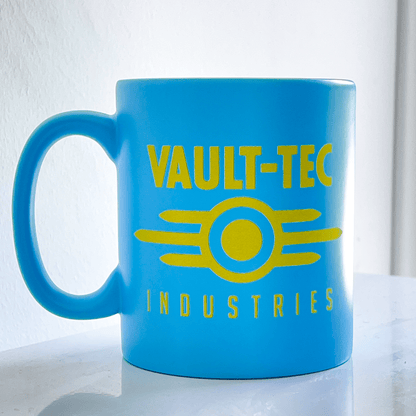 A blue Fallout mug displays the Vault-Tec Industries logo in yellow.