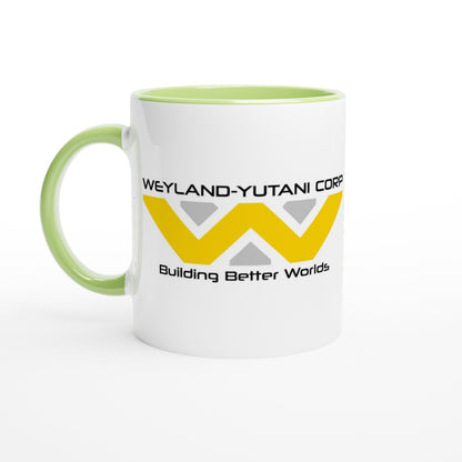 A white mug features a green handle and rim, displaying the Weyland-Yutani Corporation logo and the phrase "Building Better Worlds.