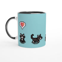A white mug displays pixel art of tuxedo cats and a heart emote referencing the Stardew Valley computer game.