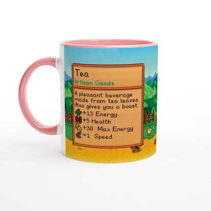 A Stardew custom tea mug features a pixelated graphic of an item card describing tea and its benefits against a background of rolling hills.