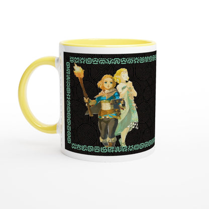 A white mug with a yellow handle and rim features an illustration of Link and Zelda from The Legend of Zelda: Tears of the Kingdom surrounded by Sheikah script patterns.