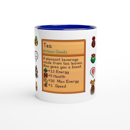 A white mug displays a Stardew Drinks pattern resembling an item card detailing tea's benefits including energy and health boosts.
