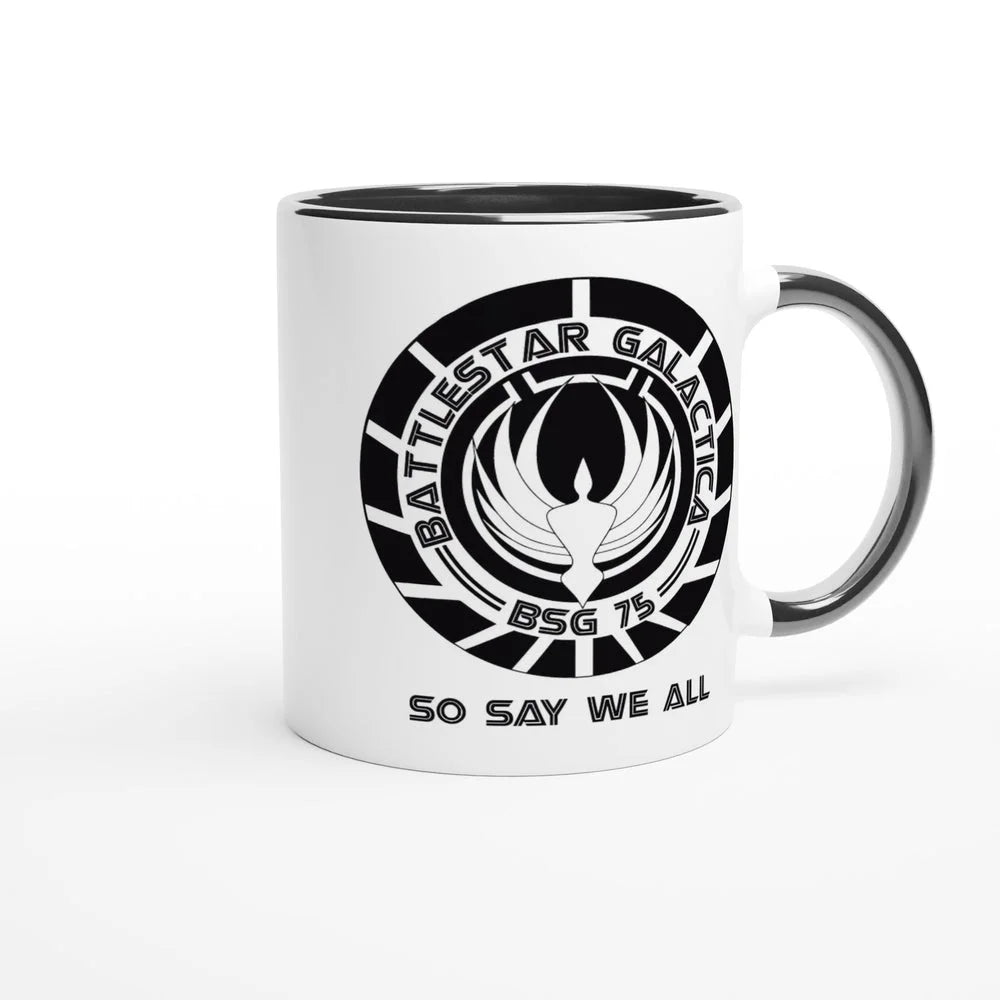 A white ceramic mug features a black rim and handle, displaying the Battlestar Galactica logo with "BSG 75" and "So Say We All" printed around it.