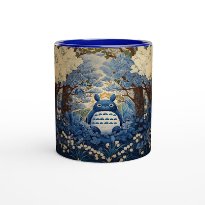 A ceramic mug depicts Totoro from Studio Ghibli sitting amongst a blue and white cherry blossom forest in a chinoiserie style.