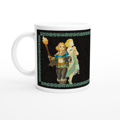 A white mug displays an illustration of Link and Zelda from The Legend of Zelda: Tears of the Kingdom, surrounded by Sheikah script patterns.