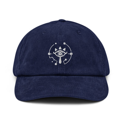 A navy blue corduroy dad hat features an embroidered Sheikah eye symbol from The Legend of Zelda: Tears of the Kingdom.