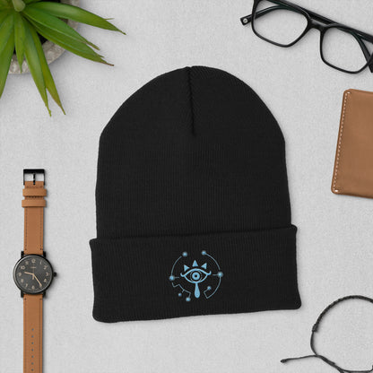 A black knitted beanie features an embroidered Sheikah eye design inspired by The Legend of Zelda: Tears of the Kingdom.