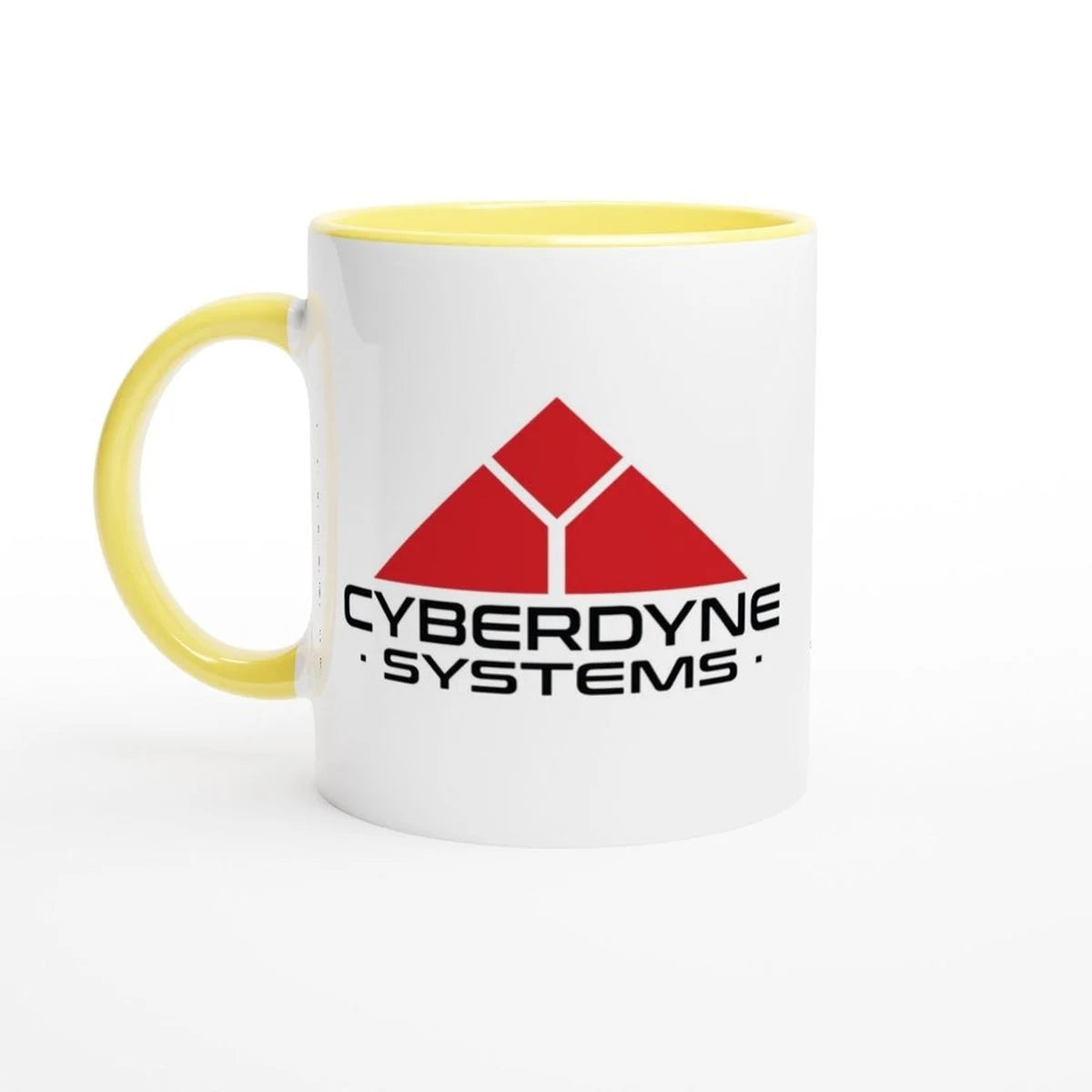 A white ceramic mug with a yellow handle and rim displays the Cyberdyne Systems logo from the Terminator 2 movie.