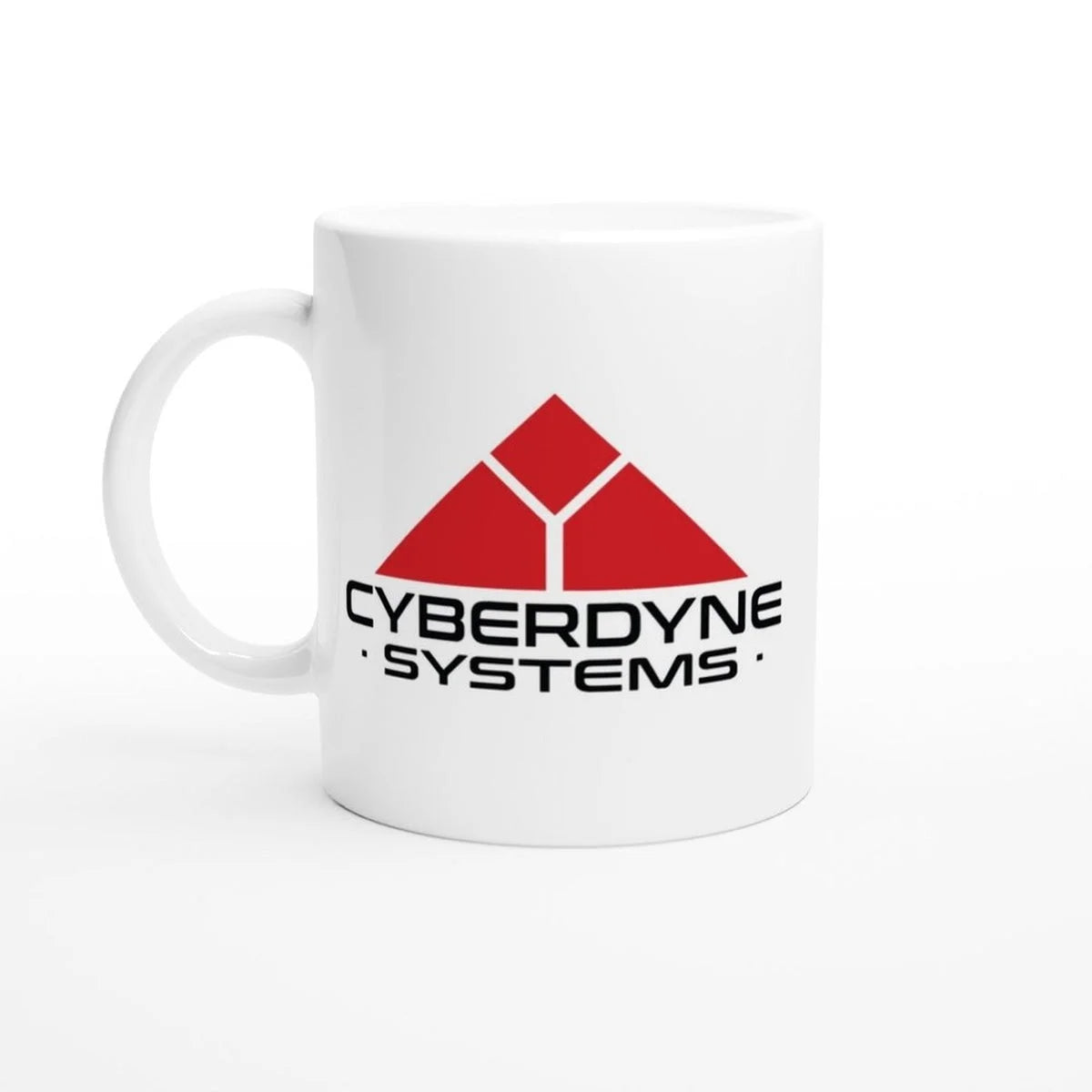 A white ceramic mug displays the Cyberdyne Systems logo, featuring a red triangular design and company name from the Terminator 2 movie.