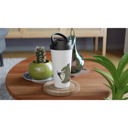 A white insulated travel mug featuring Totoro from Studio Ghibli sits on a wooden coaster next to greenery and fruit.