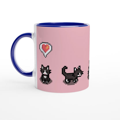 A white ceramic mug features a pink design with pixelated graphics of tuxedo cats and a heart emote referencing the Stardew Valley computer game.