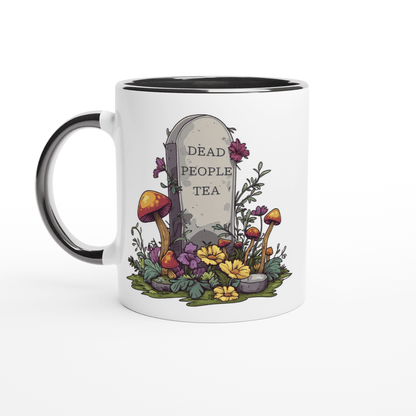 A white ceramic mug with a black handle and rim features an illustration of a tombstone surrounded by flowers and mushrooms that reads "Dead People Tea.