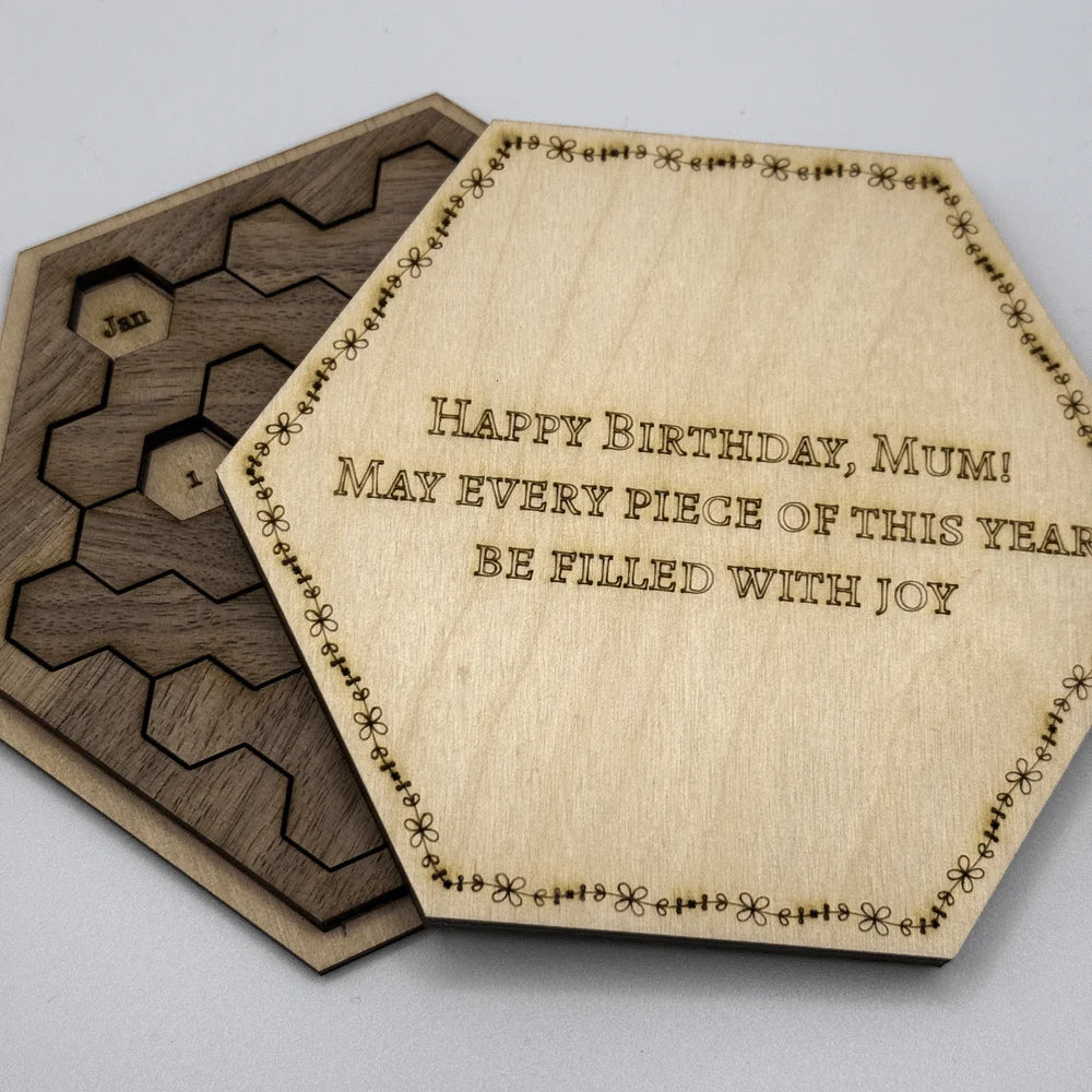 The image shows a Hexagon Calendar Puzzle Gift Edition featuring wooden tiles arranged in a hexagonal shape and inscribed with "Happy Birthday, Mum!