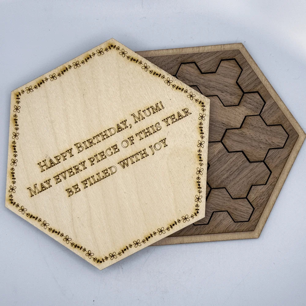 A wooden hexagon calendar puzzle features a central tile inscribed with "Happy Birthday, Mum! May every piece of this year be filled with joy.