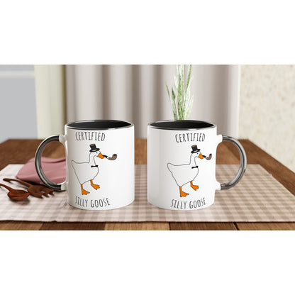 Two white mugs with a cartoon goose design and text on a wooden table.