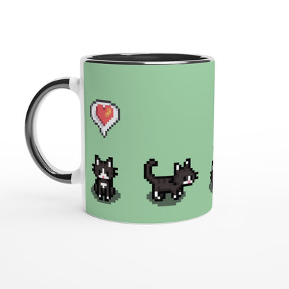 A white mug displays pixelated graphics of tuxedo cats and a heart emote referencing the Stardew Valley computer game.