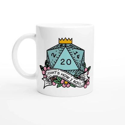A white mug displays a colorful illustration of a D&D twenty-sided die (d20) showing a "20" and a banner reading "That's How I Roll.